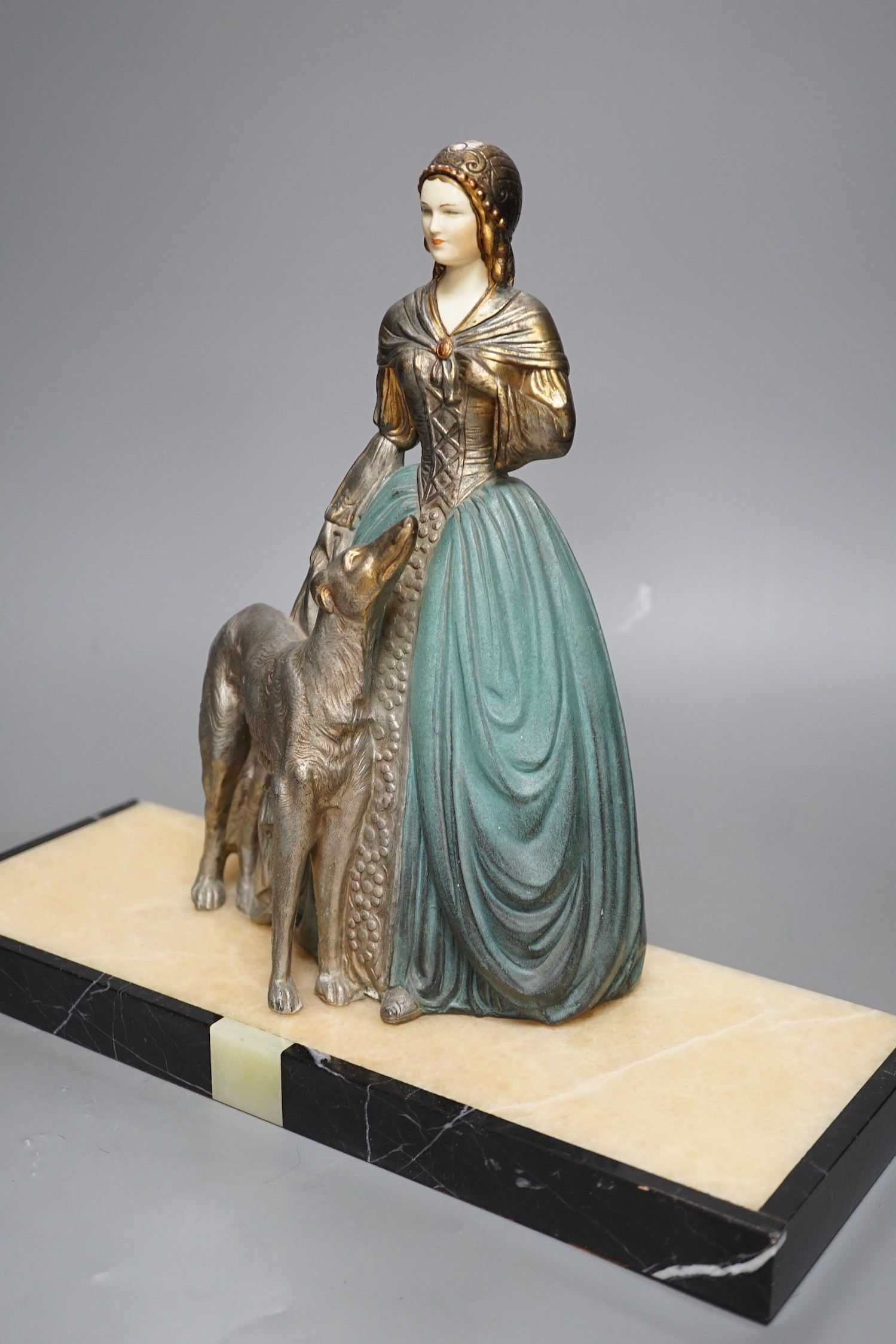 An Art Deco cold painted spelter and composition figure of a lady with a dog, signed R Miandres, 38cm wide